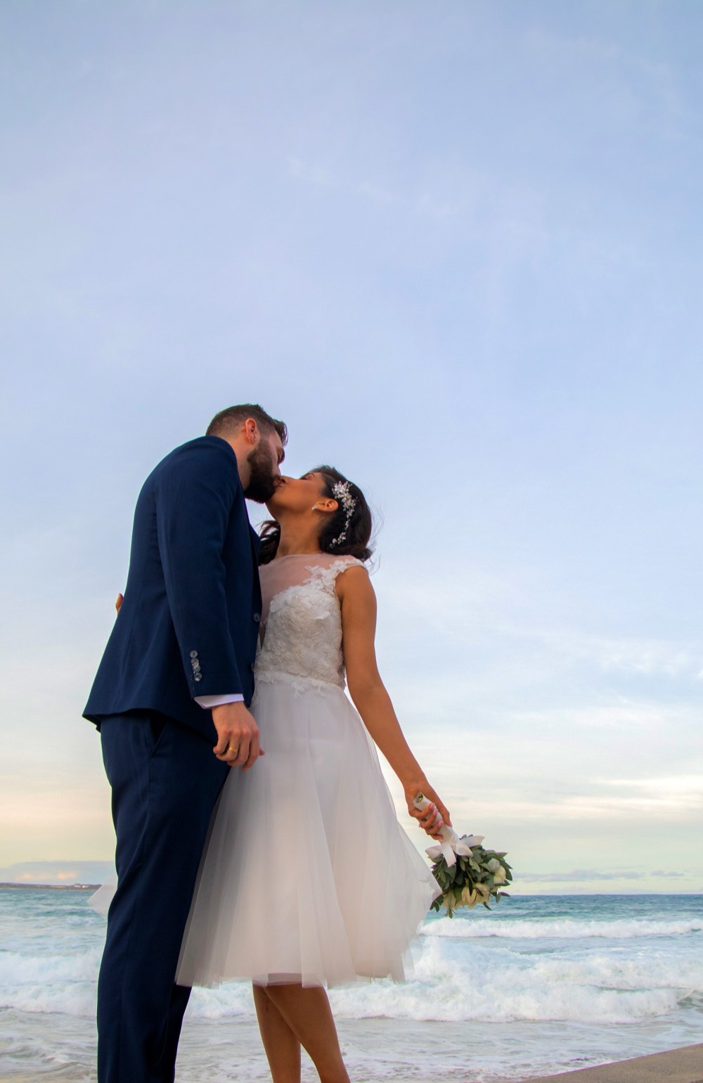 A couple embracing by the water after a commitment ceremony