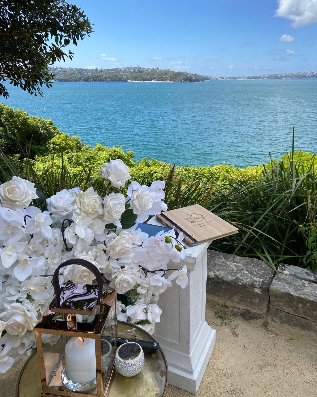 A signing table dressed with white florals above the water