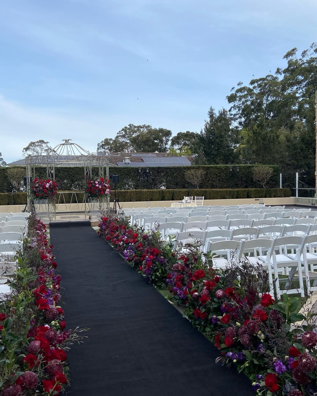 An aisle lined with florals leading to the water