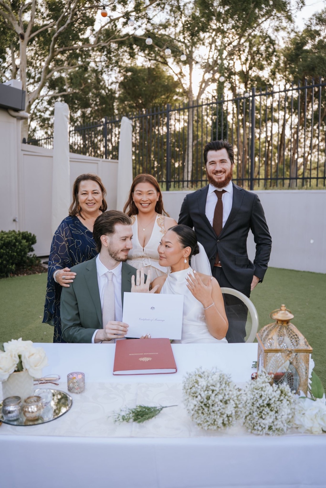 Josephine with a couple and their family at the signing table at golden hour