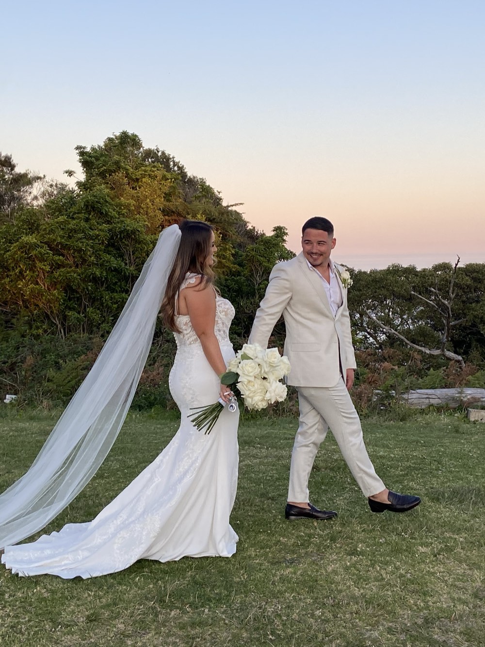 A couple walking together at sunset after their ceremony